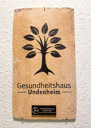 Steinmetztafel mit Logo Gesundheitshaus in beigen Stein eingraviert